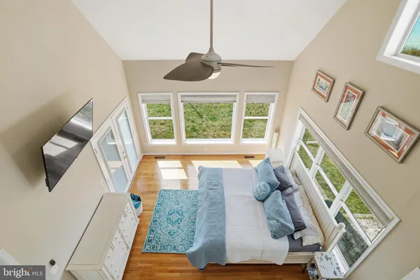 a view of a livingroom with furniture stairs wooden floor and windows