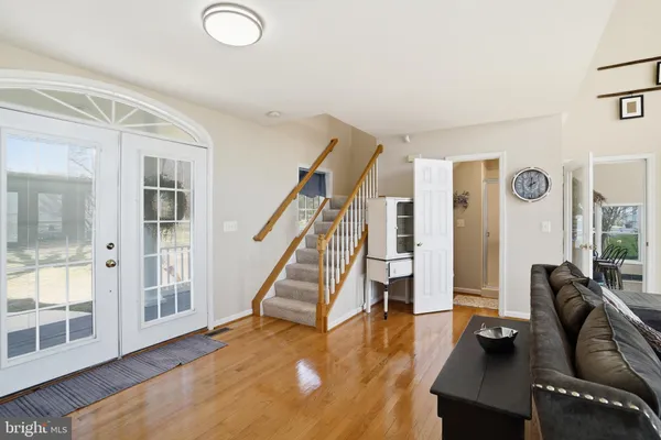 a living room with furniture and a dining table with wooden floor