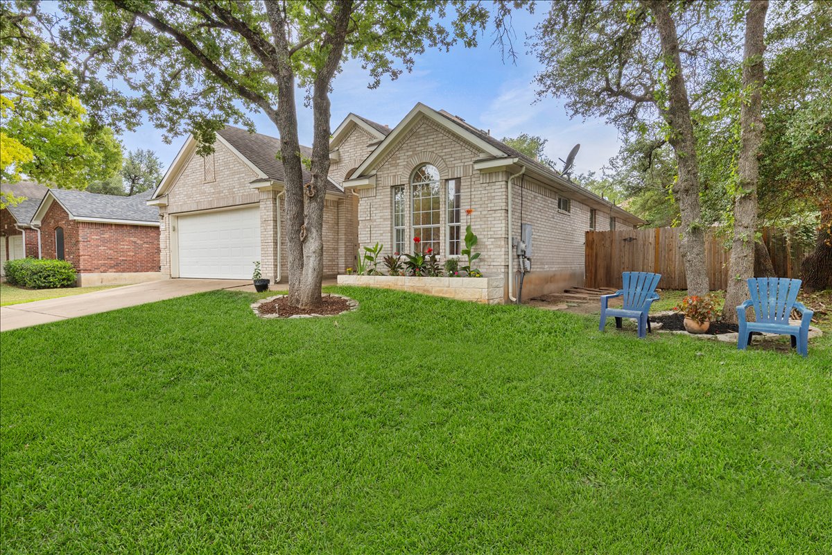 9012 Meacham Way Austin, TX 78749 - Photo 4 of 34 Light-colored brick exterior featuring an arched window, attached garage, and a fenced side yard