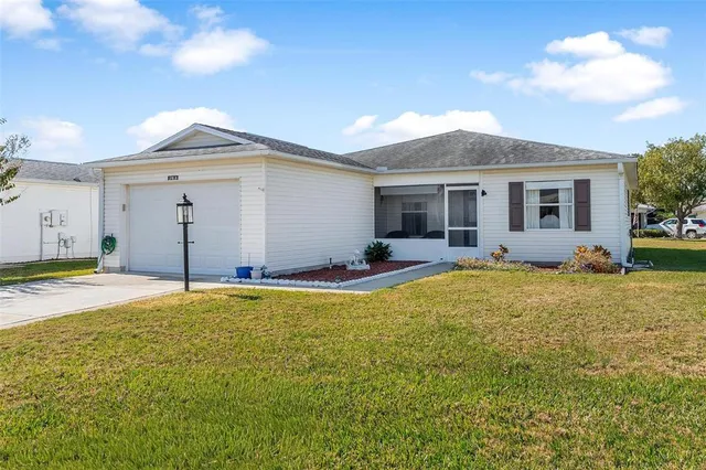 a view of a house with backyard and a tree