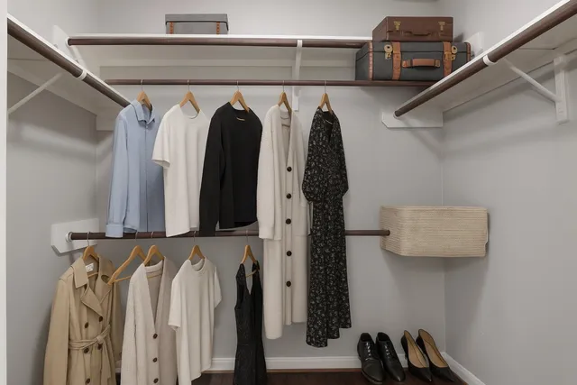 a view of walk in closet with clothes and shoes