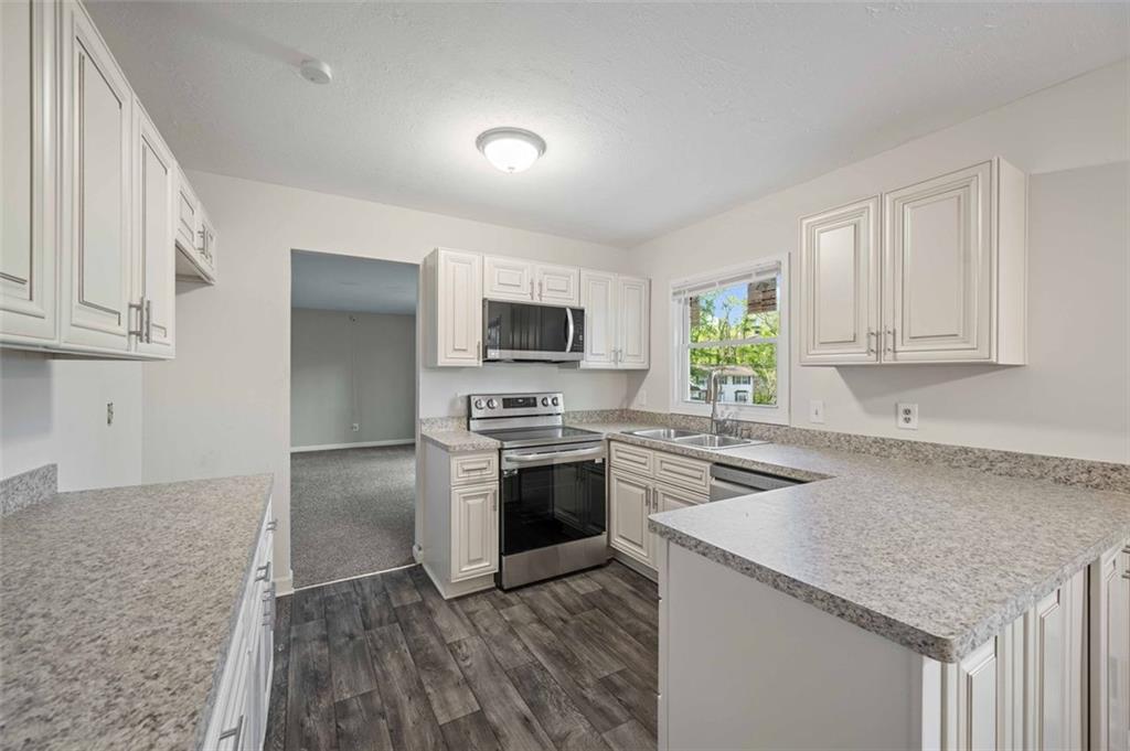 4166 Rue St Michel Stone Mountain, GA 30083 - Photo 20 of 31 a kitchen with a sink stove and refrigerator