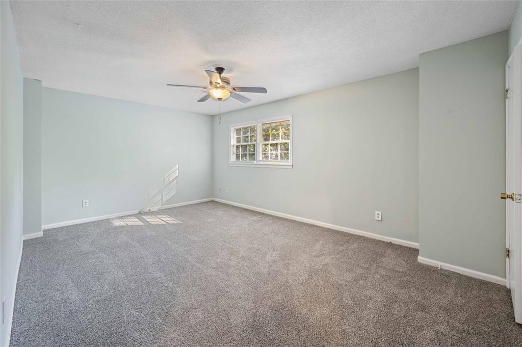 4166 Rue St Michel Stone Mountain, GA 30083 - Photo 24 of 31 an empty room with windows and ceiling fan