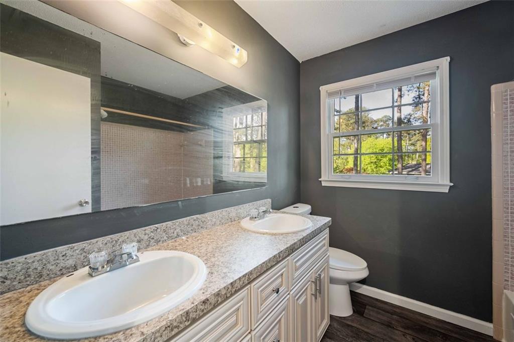 4166 Rue St Michel Stone Mountain, GA 30083 - Photo 26 of 31 a bathroom with a granite countertop sink mirror vanity and toilet