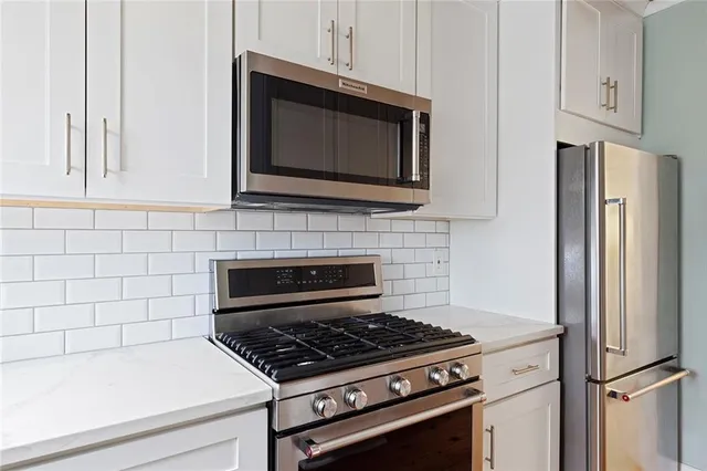 a kitchen with granite countertop a stove and a microwave