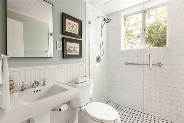 a bathroom with a toilet sink and mirror