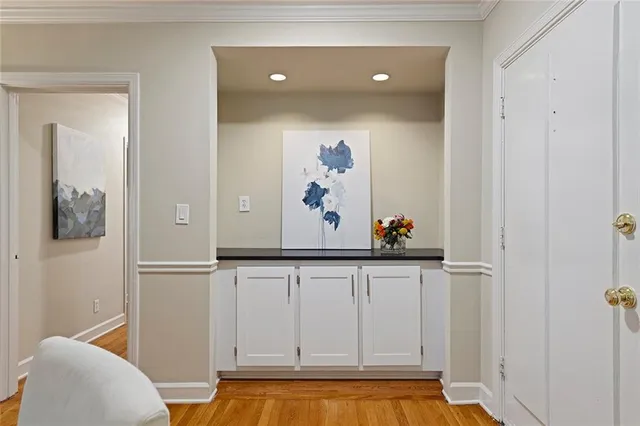 a view of a hallway with wooden floor and cabinet