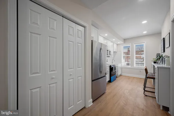a view of a hallway with furniture and wooden floor