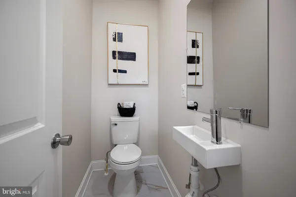 a white toilet sitting next to a bathroom sink