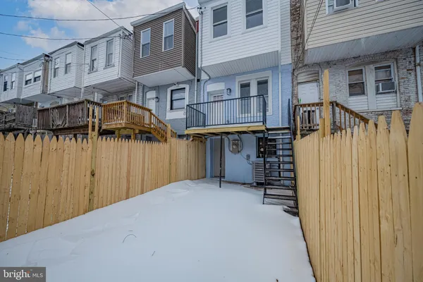 a view of a house with a wooden fence