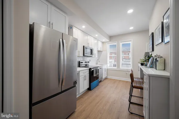 a kitchen with stainless steel appliances a refrigerator and a stove top oven