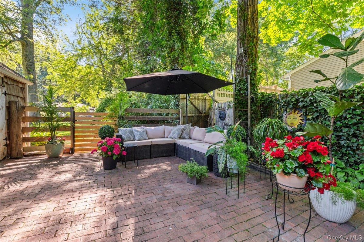10 Rancher Place Huntington, NY 11743 - Photo 34 of 44 Brick paver patio featuring a slatted wood fence and a shingled shed