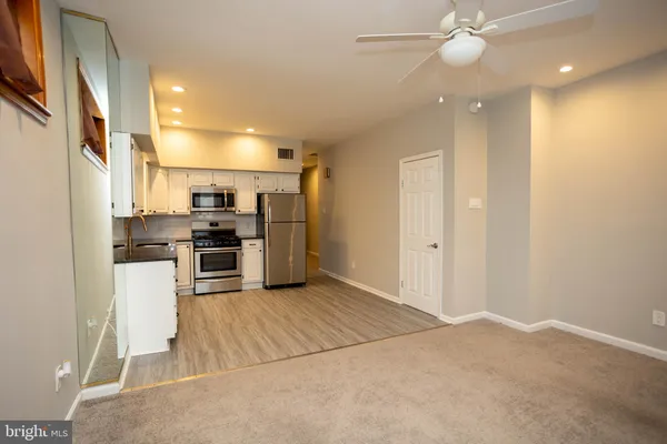 a kitchen with stainless steel appliances kitchen island granite countertop a refrigerator and a sink