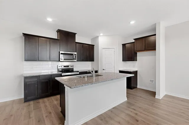 a view of kitchen with sink microwave and stove top oven