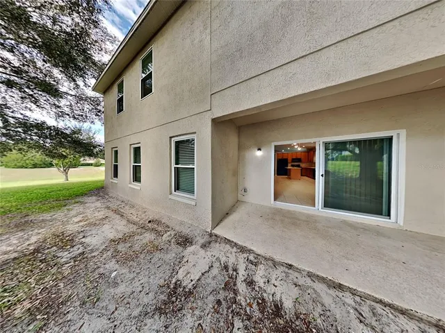 a view of a house with a yard and potted plants
