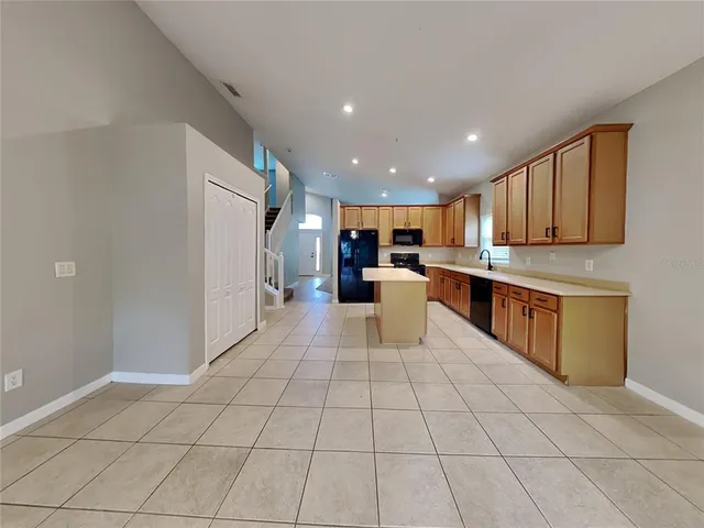 a kitchen with stainless steel appliances granite countertop a refrigerator and a stove top oven