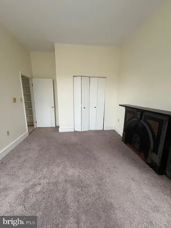 a big room with a fireplace and wooden floor