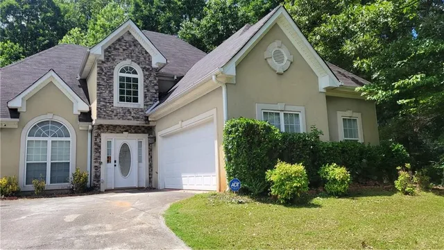 a front view of a house with a yard and potted plants