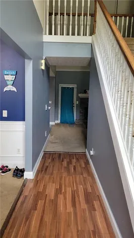 a view of a hallway with wooden floor and staircase