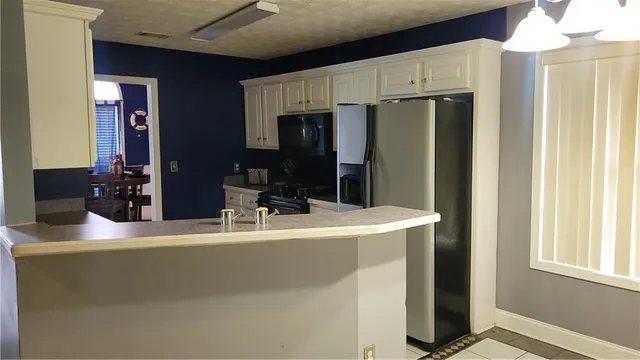 a room with kitchen island a counter top space and stainless steel appliances