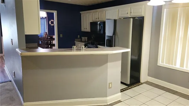 a view of kitchen with stainless steel appliances granite countertop cabinets and a refrigerator
