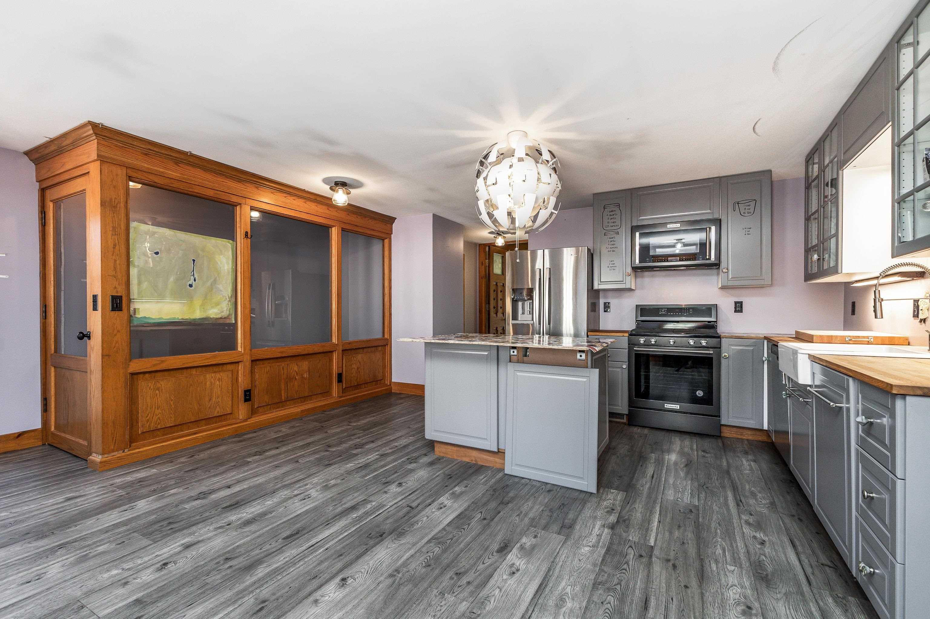 330 Spring Street Galena, IL 61036 - Photo 9 of 27 a kitchen with stainless steel appliances granite countertop a refrigerator a sink dishwasher a stove and white countertops with wooden floor
