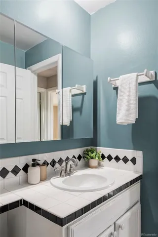 a bathroom with a granite countertop sink and a mirror