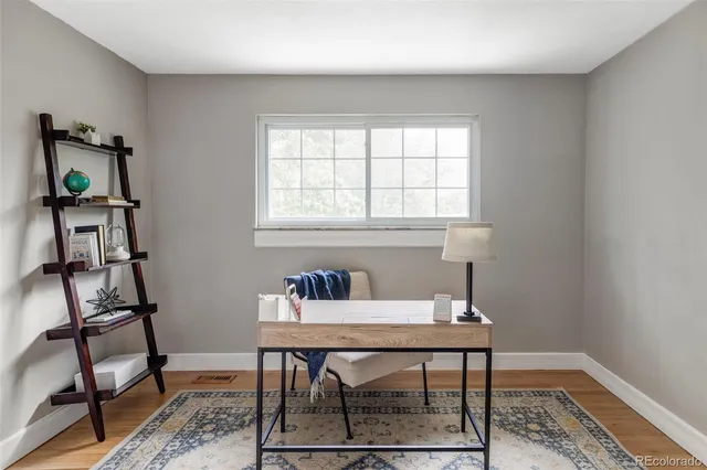 a workspace room with furniture and wooden floor