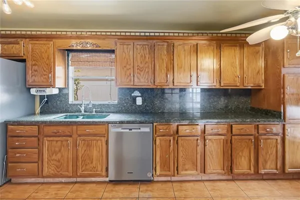 a kitchen with granite countertop a sink and cabinets
