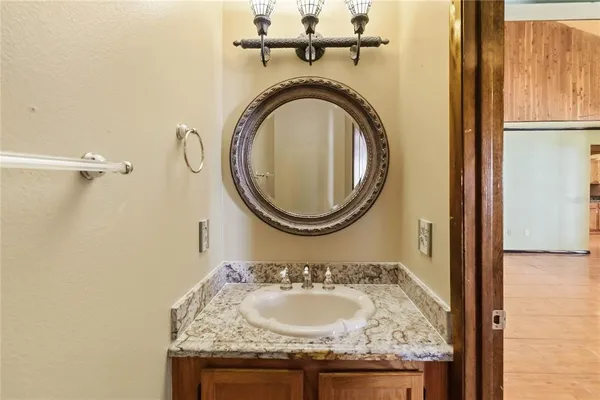 a bathroom with a granite countertop sink and a mirror