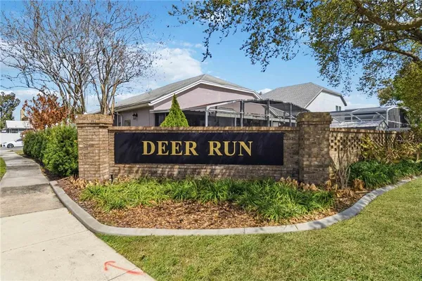a view of a sign board with large trees