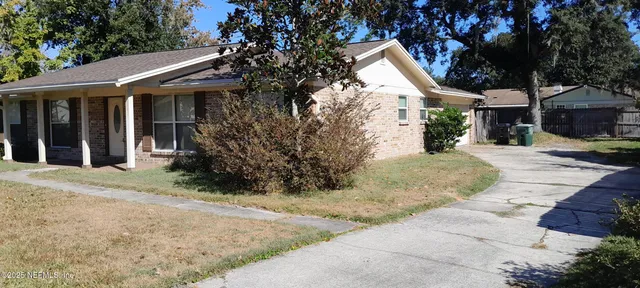 a view of a white house with a large tree