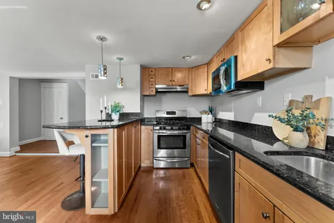 a kitchen with stainless steel appliances granite countertop a stove a sink and a refrigerator