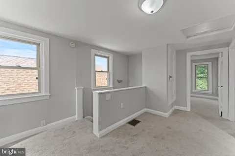 a view of an empty room with closet and a window