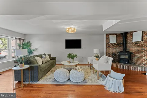 a living room with couches and a flat screen tv with kitchen view