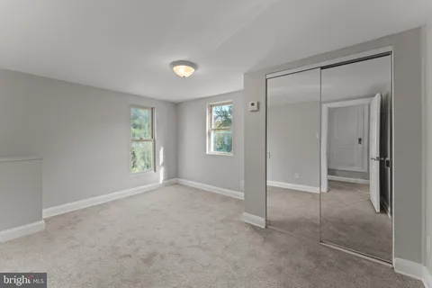 an empty room with windows and closet