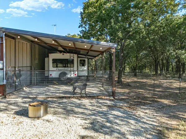 a view of a patio with table and chairs and wooden fence