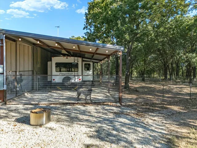 a view of a patio with table and chairs and wooden fence