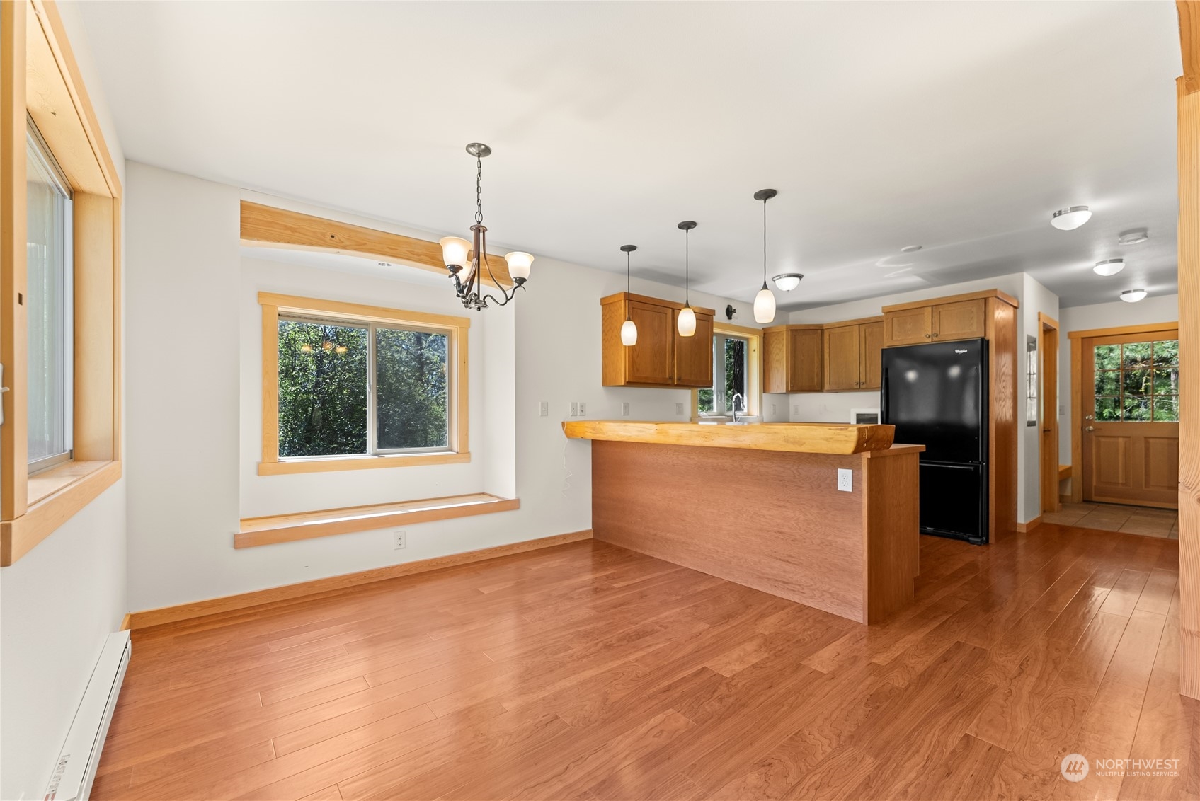 81 Homestead Road Winthrop, WA 98862 - Photo 22 of 39 a large kitchen with kitchen island a sink dishwasher a refrigerator and a fireplace with wooden floor