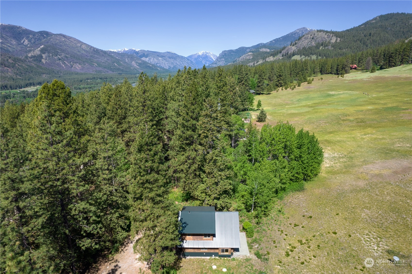 81 Homestead Road Winthrop, WA 98862 - Photo 4 of 39 a view of a lush green hillside and a houses