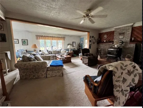 a living room with furniture ceiling fan and a window
