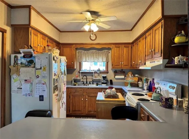 a kitchen with a refrigerator a sink dishwasher and a stove with wooden floor