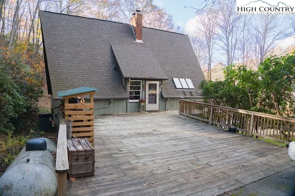 a backyard of a house with wooden stairs and a bench