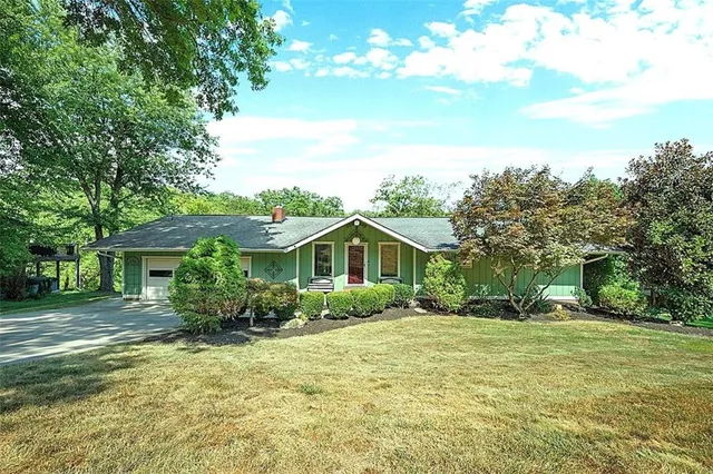 a front view of house with yard and green space