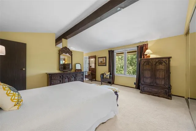 a bed sitting in a spacious bedroom next to a window