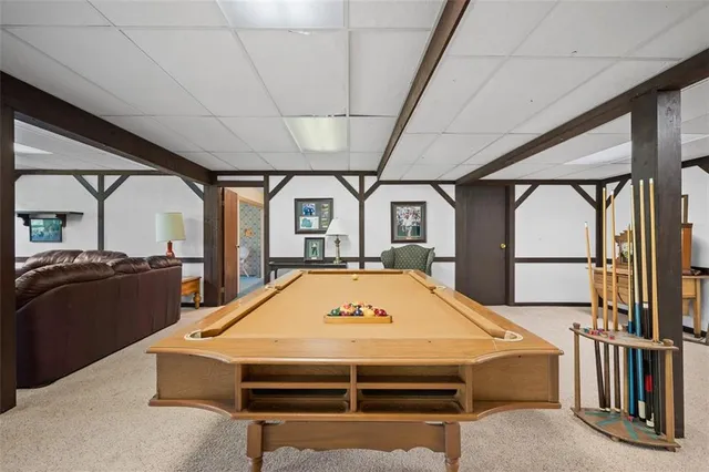 a room with pool table and windows