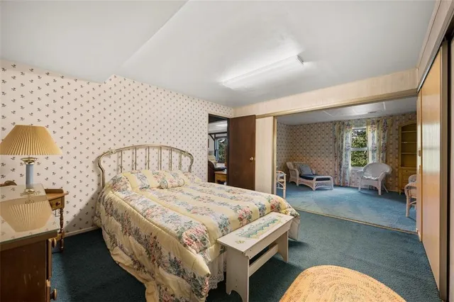 a bedroom with a bed couch and a large window