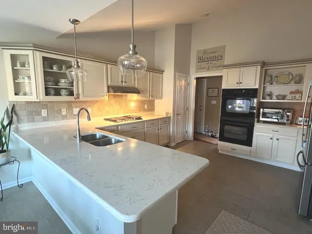 a kitchen with stainless steel appliances granite countertop a sink a oven and a refrigerator