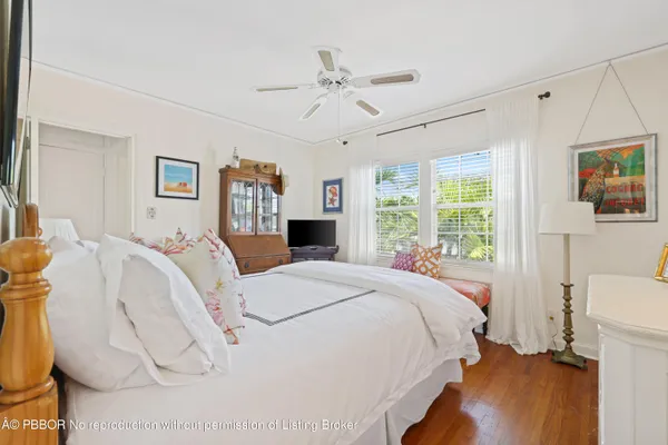a sidewalk with a building and trees in the background