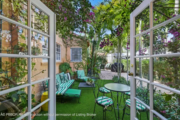 a view of a patio with a table and chairs under an umbrella